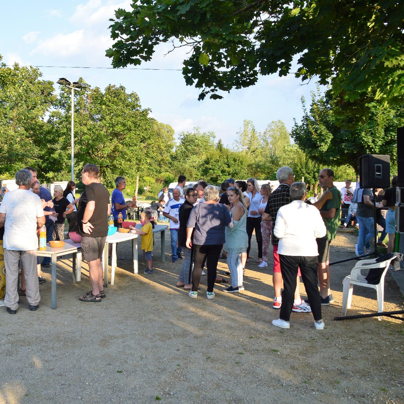 Groupe de personnes rassemblées en plein air lors d'un événement communautaire.